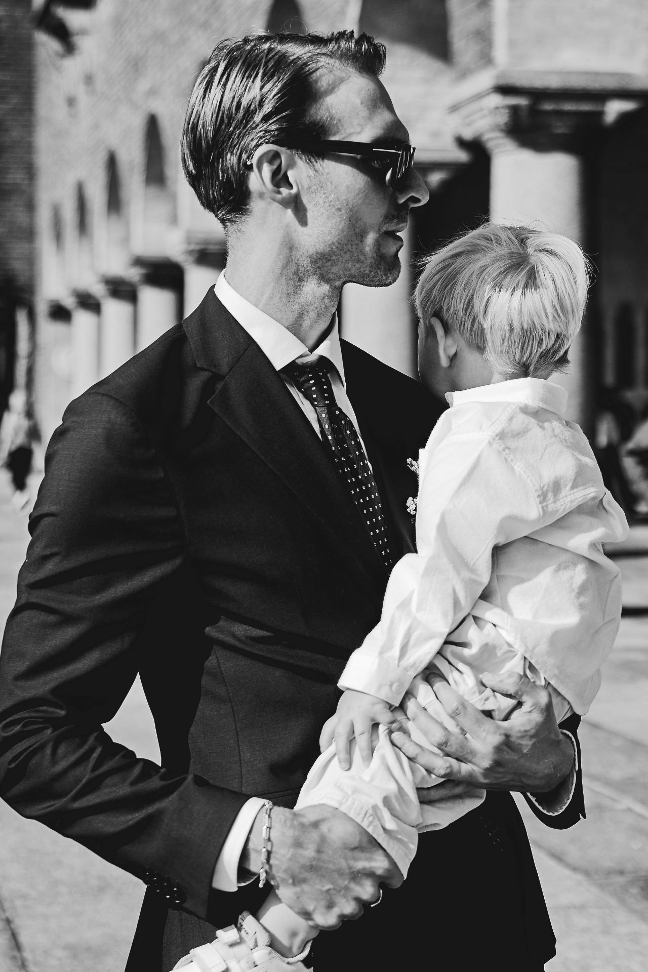 The groom carrying his son past the colonnade