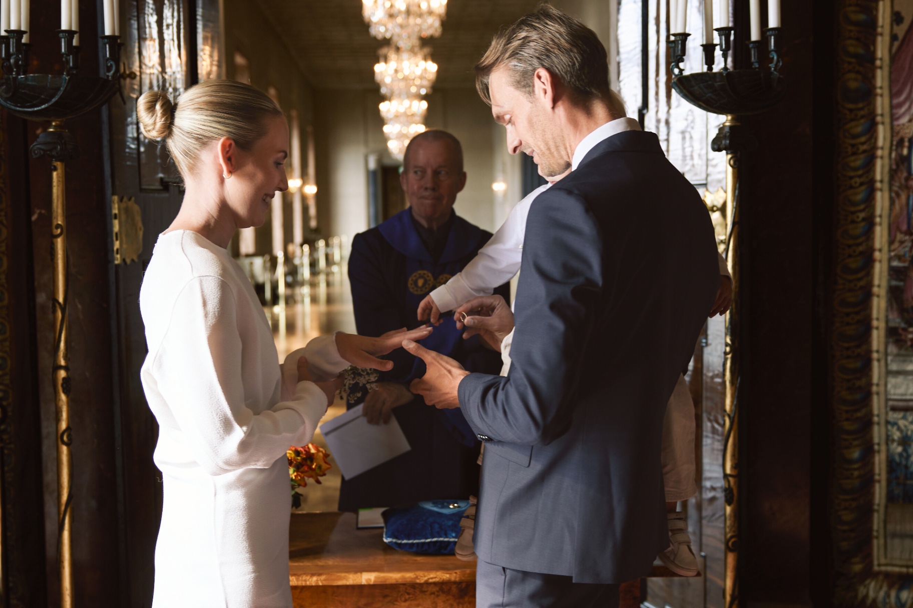 Elin and Simon exchanging rings with their son in arm