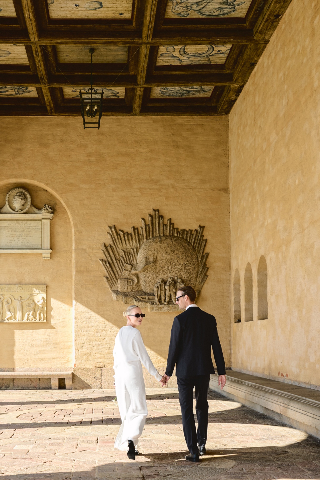 Walking hand in hand beneath the painted ceiling
